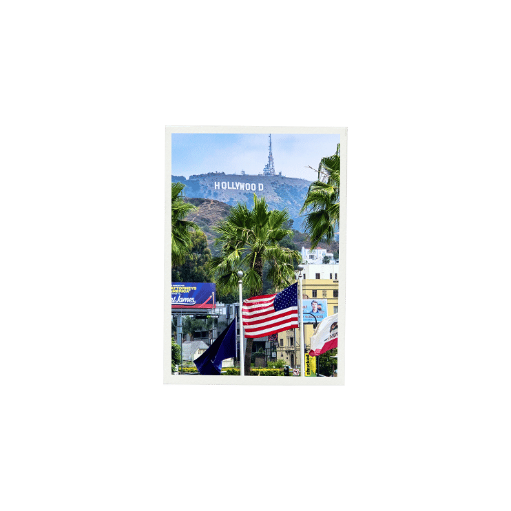 Vue sur le panneau Hollywood à Los Angeles, avec palmiers et drapeaux américains.