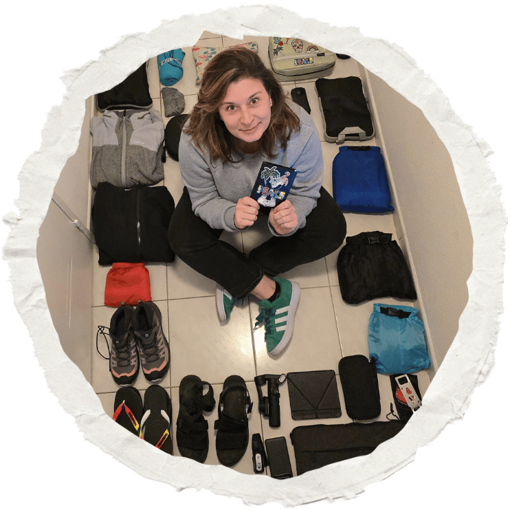 Magalie assise au milieu de ses affaires de voyage, préparant son sac à dos pour un long voyage solo autour du monde.