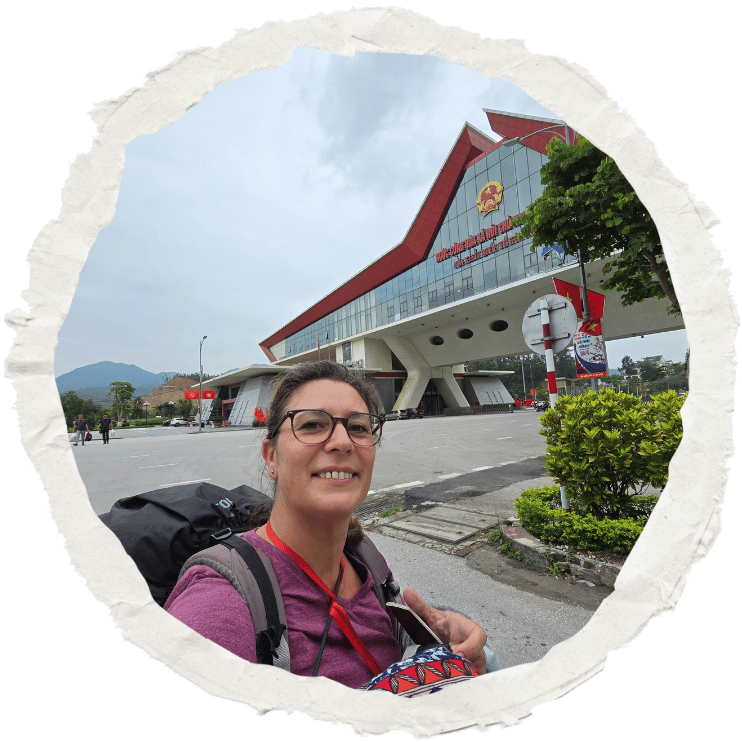 Magalie avec son sac à dos devant le poste-frontière entre le Vietnam et la Chine, prête à franchir une nouvelle étape de son voyage solo.