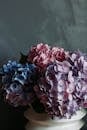 A close-up of a hydrangea bouquet with pink and blue blossoms, creating a serene and elegant aesthetic against a neutral background.