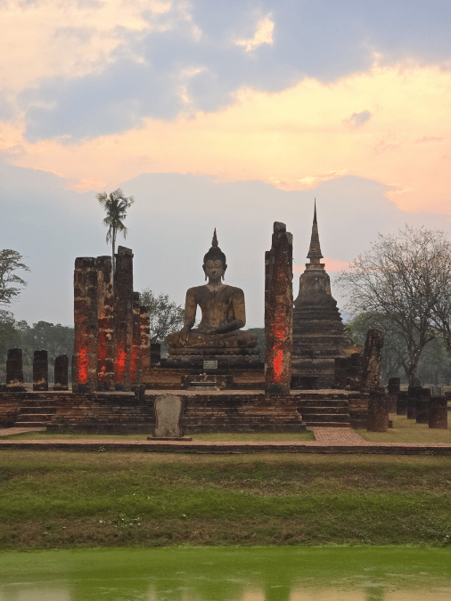Coucher de soleil sur le Bouddha et le chedi de Wat Mahathat, parc historique de Sukhothaï